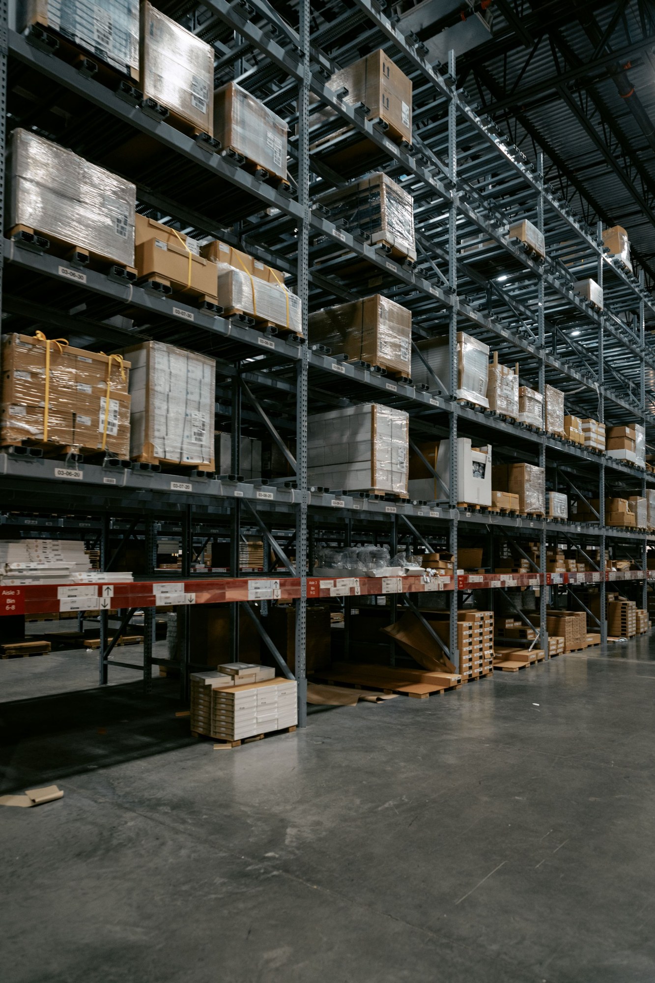 Palletized cartons arranged on tall industrial warehouse racks